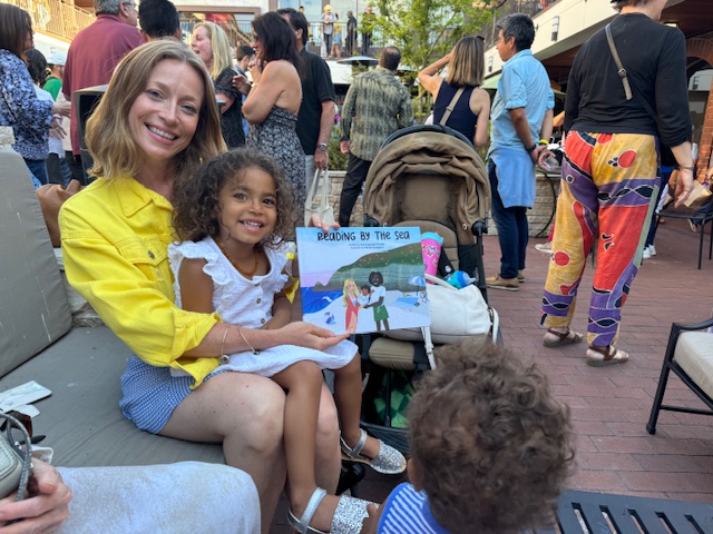 Eva reading with her daughter at a book event